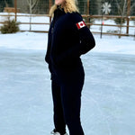 Black full zip fitted Canadian Jacket with Canada flag on left arm. Girl on ice rink